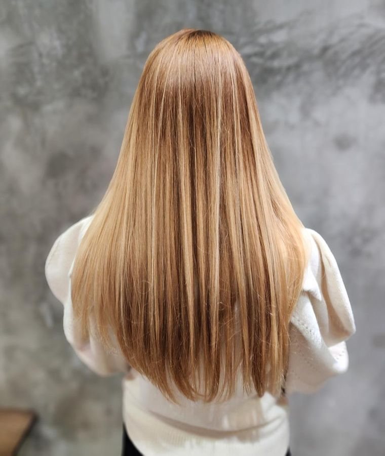 Long, smooth blowout styled through hair extensions