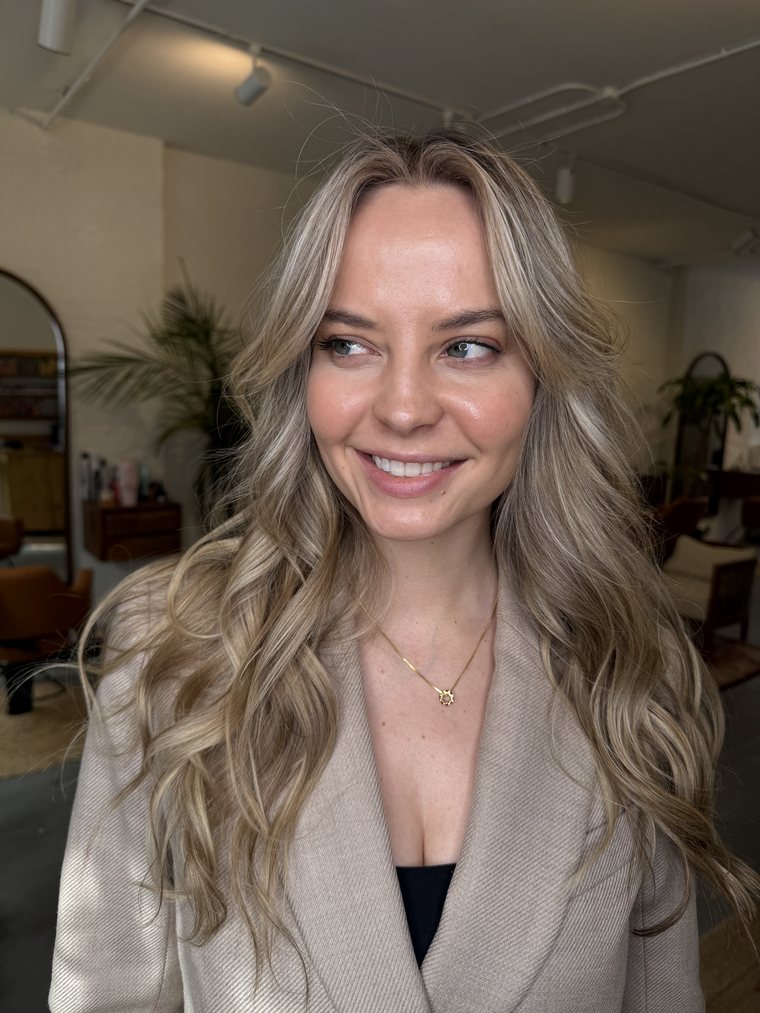 A client styled with soft blonde waves at a private residence appointment